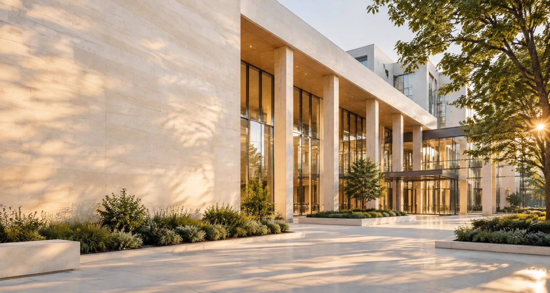 Sunlit limestone and glass entrance of a modern medical campus